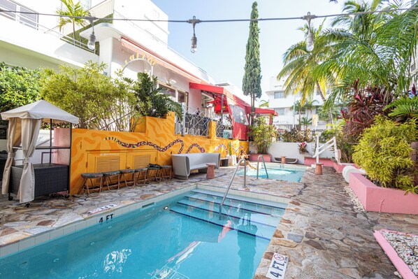Relax by the rectangular pool surrounded by a deck and a seating area with a table and chairs.