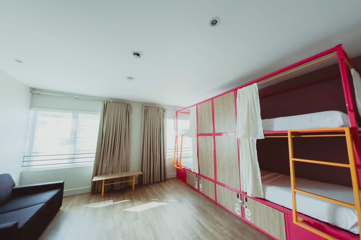 A room with a bunk bed, a bench, and a desk.