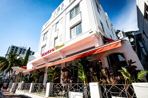 Welcome to Viva Rio, a charming hotel with a classic white facade and beautiful potted plants.