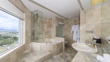 A modern bathroom with a glass-enclosed shower, a freestanding bathtub, and a sink.