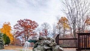 A swimming pool with a stone structure and a wooden deck. - Chateau Resort & Conference Center (Tannersville)