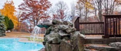 Una piscina con una estructura de piedra y una cubierta de madera.