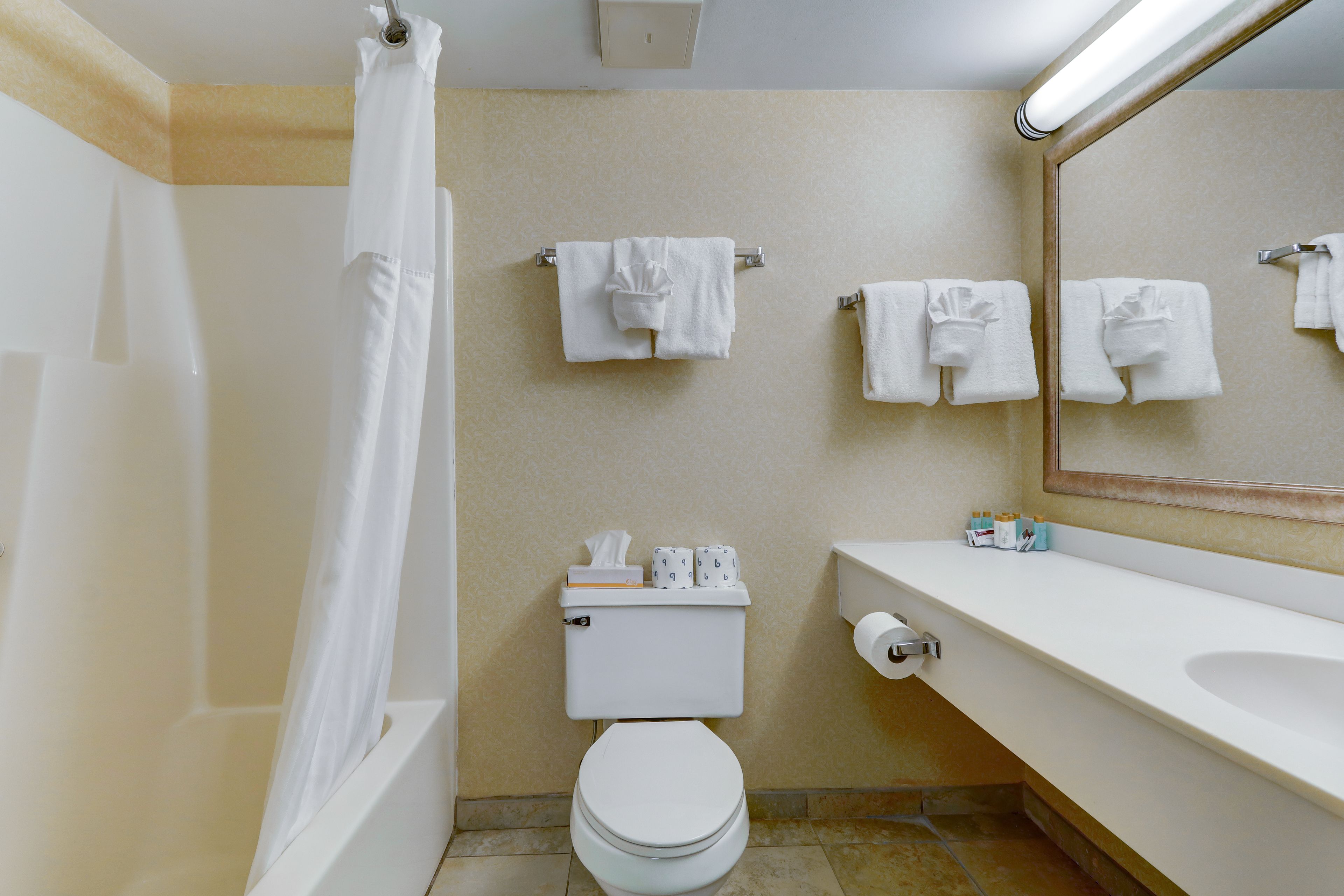 A bathroom with a bathtub, toilet, and sink.