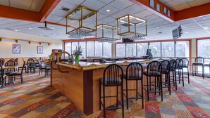 A restaurant with a bar area, multiple chairs, and a patterned carpet. - Chateau Resort & Conference Center (Tannersville)