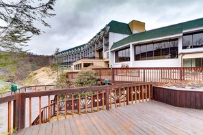 A hotel with a wooden deck, multiple balconies, and a view of the surrounding landscape. - Chateau Resort & Conference Center (Tannersville)