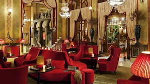 A luxurious hotel lobby with red upholstered seating, chandeliers, and ornate decor. - Hôtel Barrière Le Royal Deauville (Deauville)