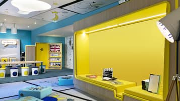 Children can play and learn in this vibrant play area with a large window, seating options, and educational decorations.