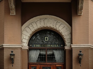 An arched entrance with the sign "THE DRISKILL" above a wooden door.