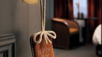 A door with a rope handle and a sign that reads 'Hold Your Horses.'