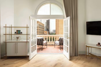 Enjoy city views from the arched window and relax on the balcony with two cushioned chairs. at The Driskill, in The Unbound Collection by Hyatt