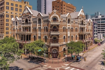 Stunning historic building with ornate facades and multiple levels, set amidst lush green surroundings. at The Driskill, in The Unbound Collection by Hyatt