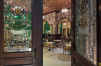 Step into the historic dining area, featuring ornate stained glass windows and a warm atmosphere. at The Driskill, in The Unbound Collection by Hyatt