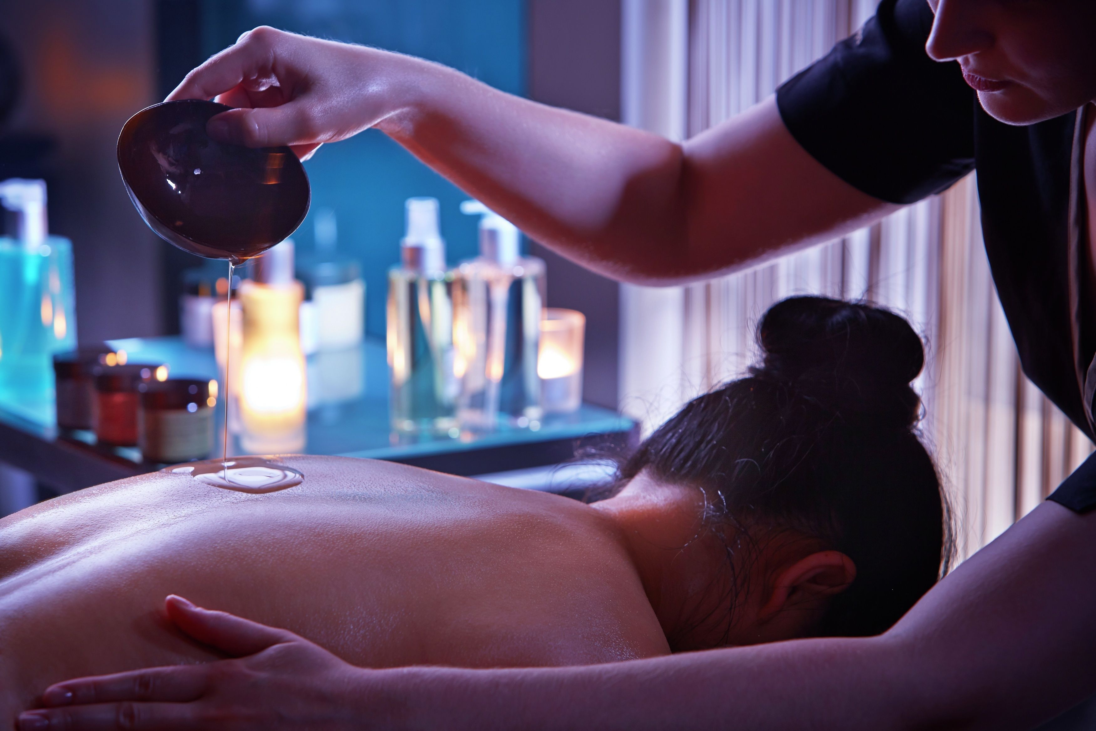 Une séance de massage où la personne est allongée sur le ventre et reçoit un massage.