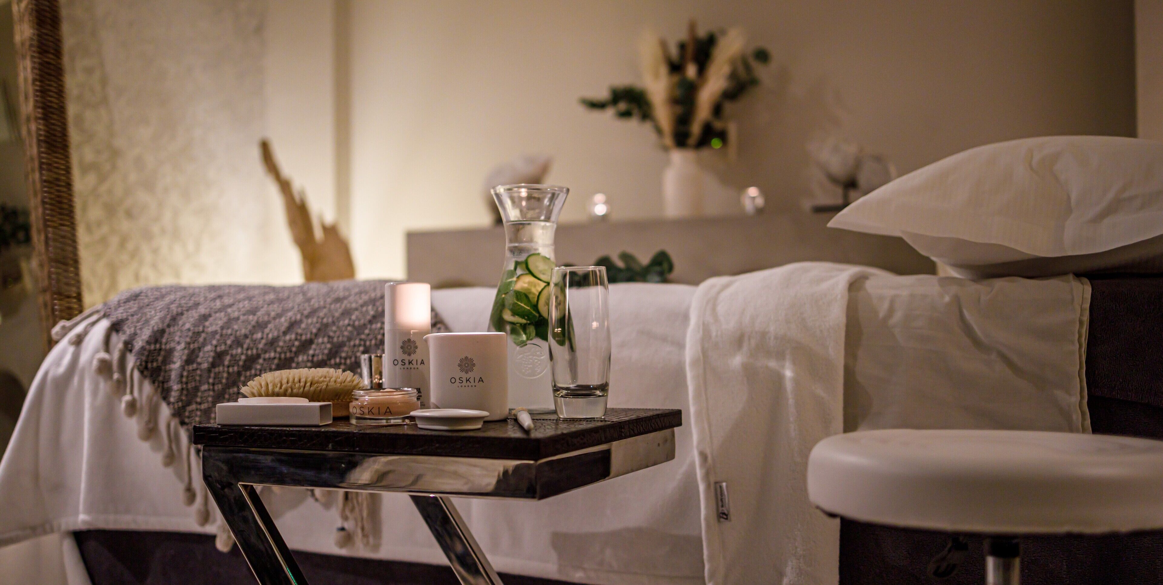 A neatly arranged bedroom with a bed, bedside table, and a small stool.