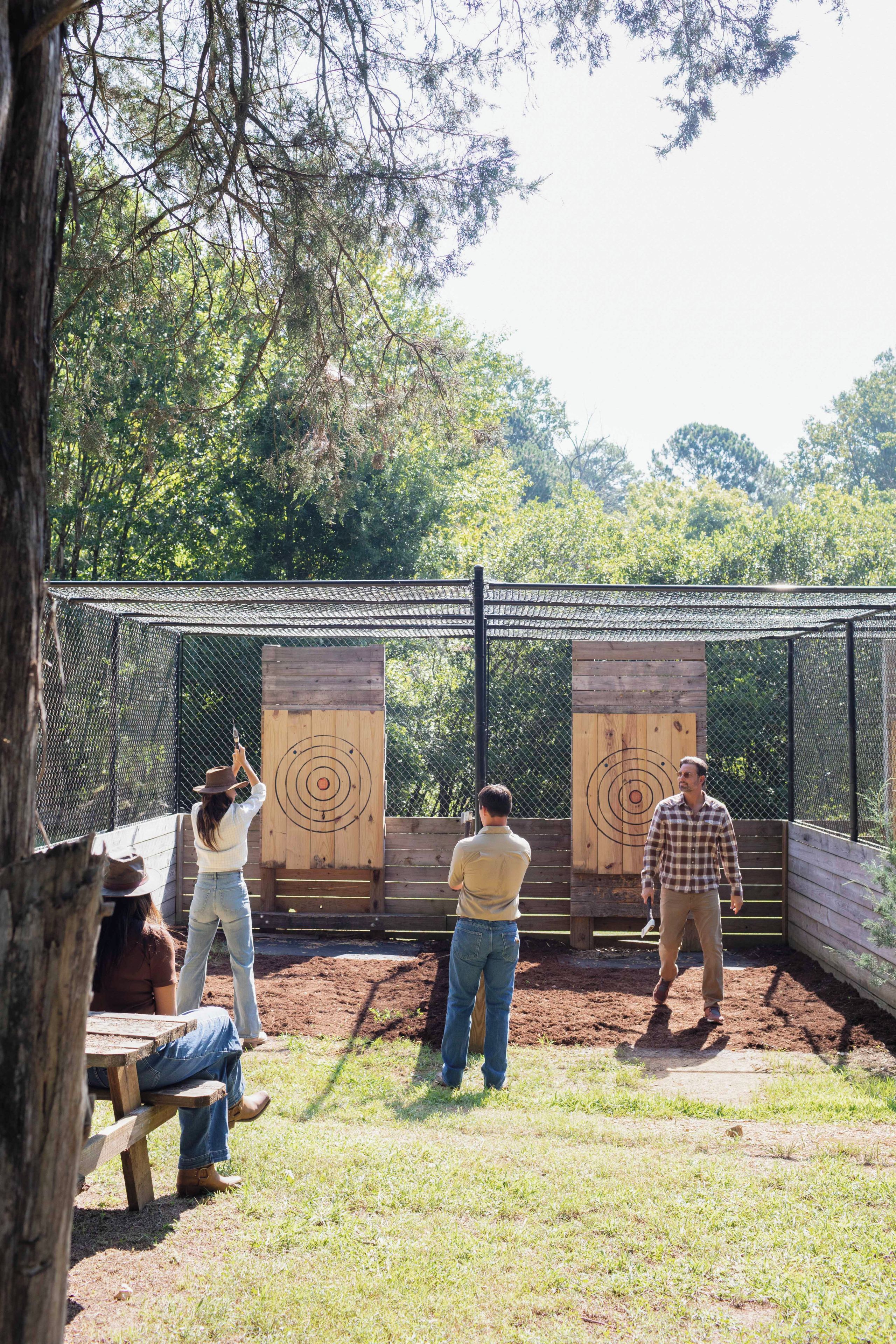 An outdoor shooting range with targets and a fence.