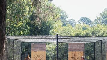 An outdoor shooting range with targets and a fence.