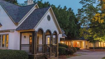 A two-story house with a porch, a chimney, and a well-maintained lawn.