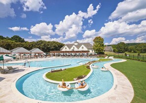 A resort with multiple swimming pools, lounge areas, and a large building in the background. - Barnsley Resort (Adairsville)