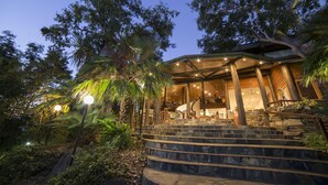 A building with a curved roof and a staircase leading to a covered area. - Thala Beach Nature Reserve (Oak Beach)