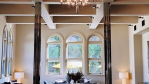 A spacious lobby with a modern chandelier, large windows, and a seating area with a vase of flowers. - Lancemore Mansion Hotel Werribee Park (Werribee South)