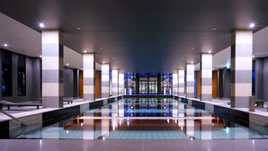 A modern hotel lobby with a central pool, seating areas, and a reception desk. - Lancemore Mansion Hotel Werribee Park (Werribee South)