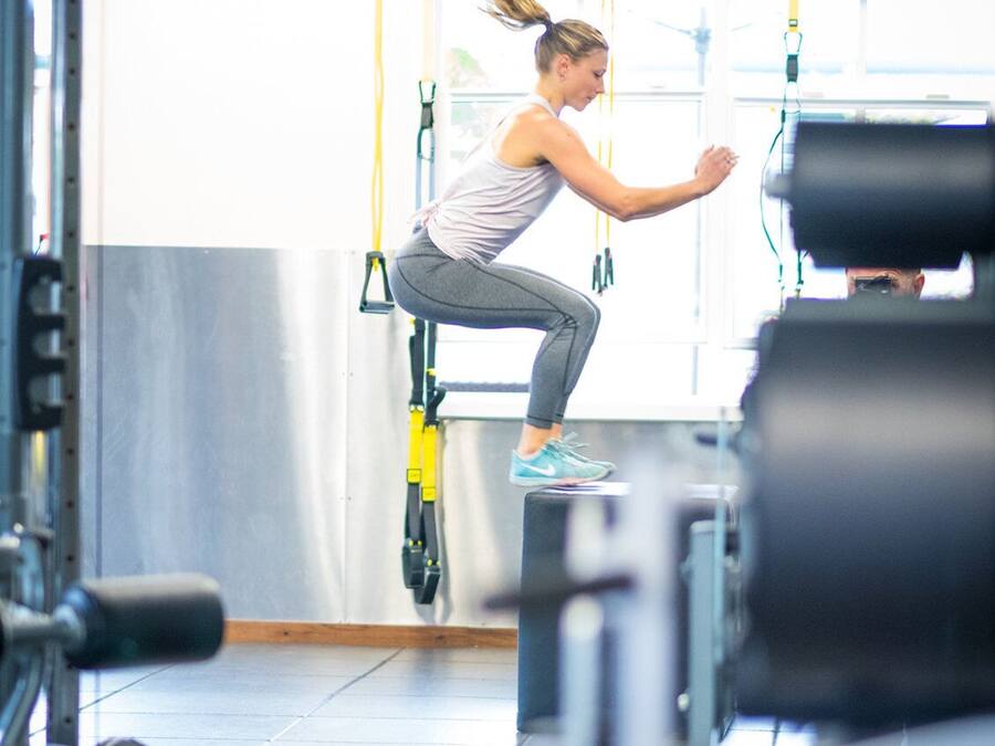 A gym with exercise equipment, including TRX handles and weight machines.