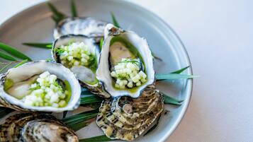 Une assiette d’huîtres, garnie d’oignons et d’herbes aromatiques coupés en dés.