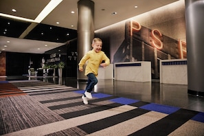 Welcome to the hotel lobby, featuring a spacious reception area with a digital display and comfortable seating.