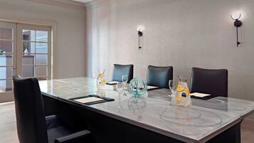 A conference room with a marble table, black chairs, and decorative glassware.
