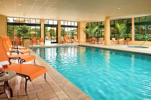 Een binnenzwembad, een buitenzwembad en parasols bij het zwembad