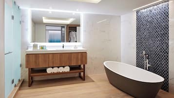 A modern bathroom with a freestanding bathtub, a vanity with a mirror, and a shower area.