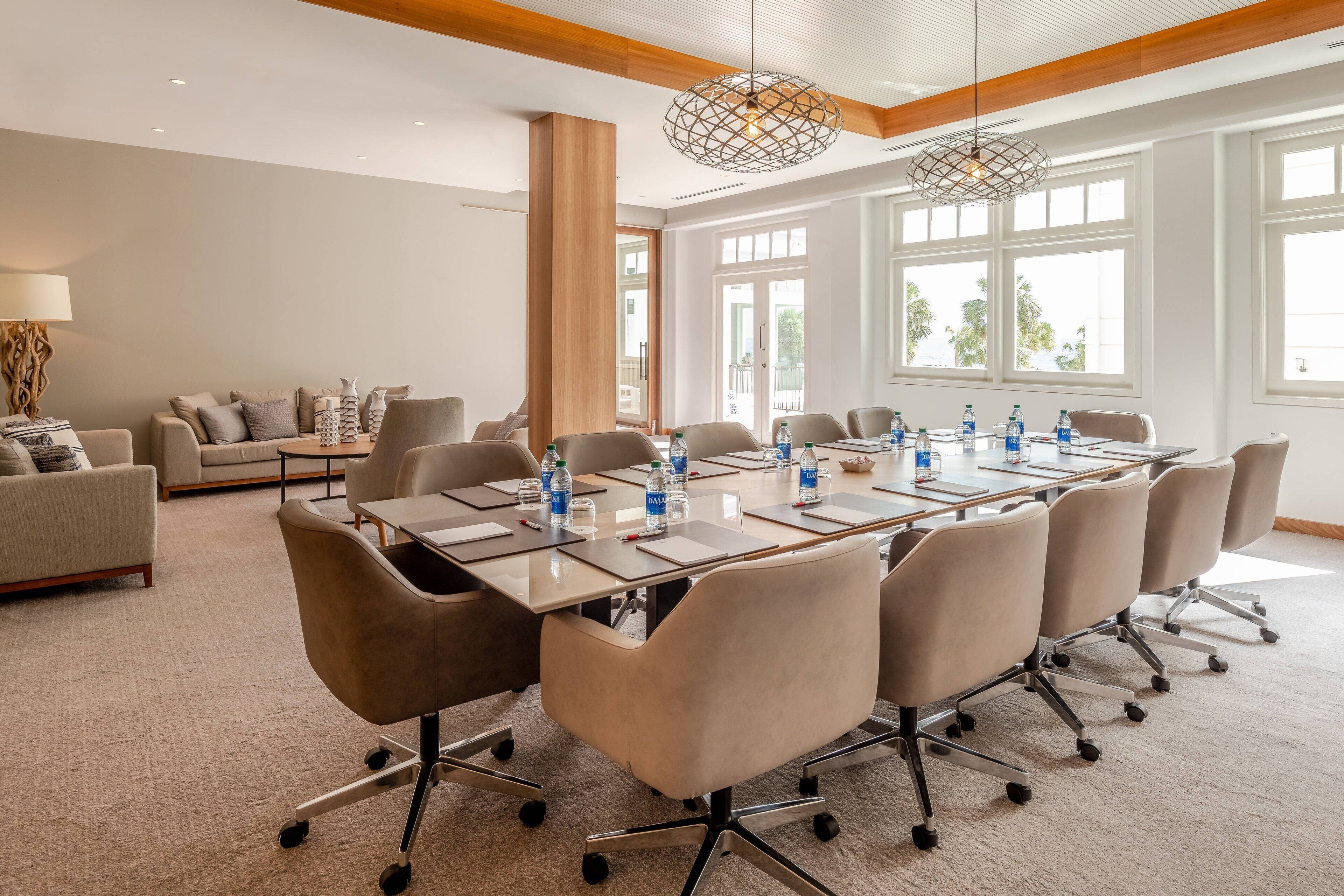 A conference room with a long table, multiple chairs, and water bottles.