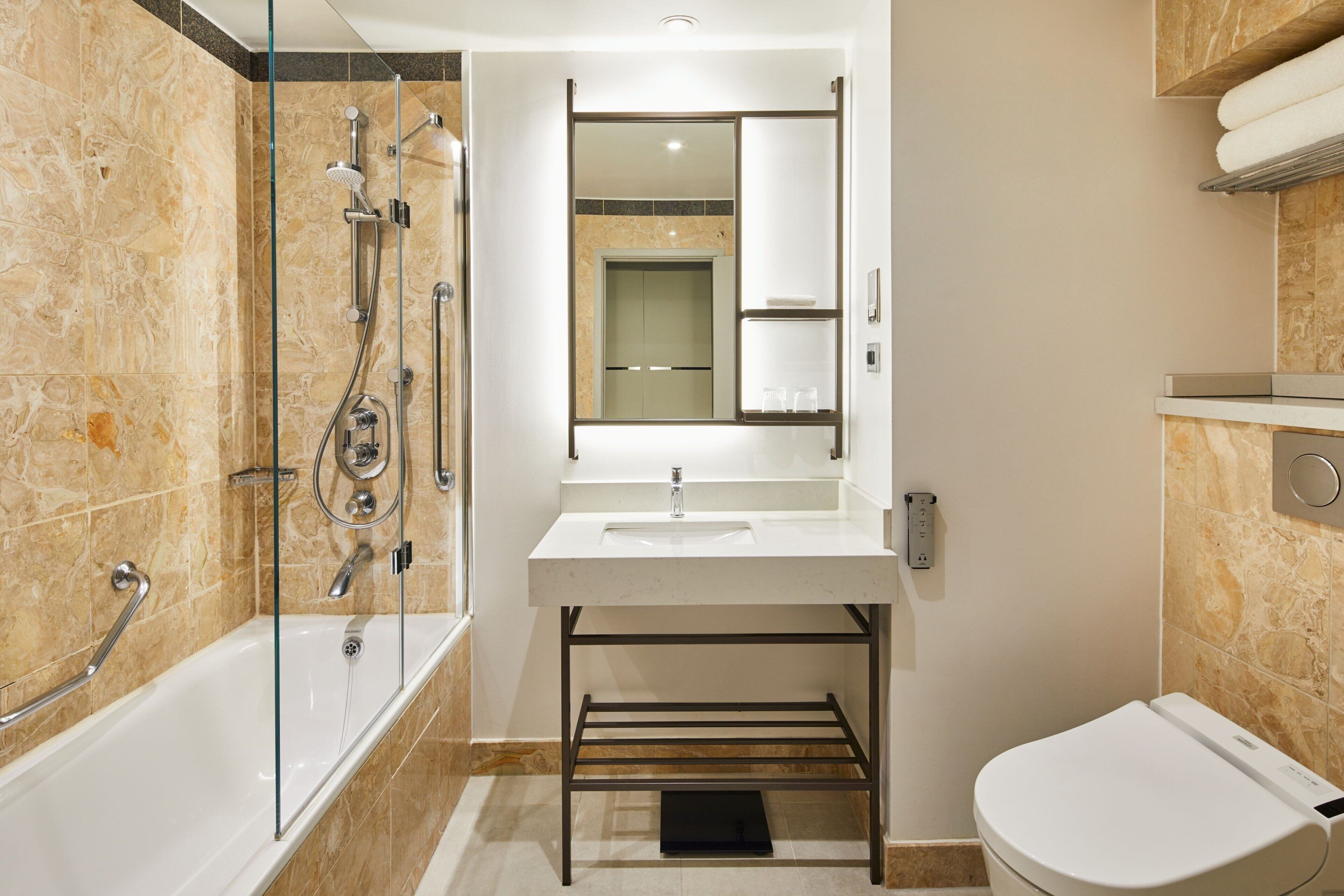 A modern bathroom with a glass-enclosed shower, a white sink, and a toilet.