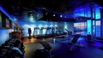 A gym with treadmills, weights, and a bench.