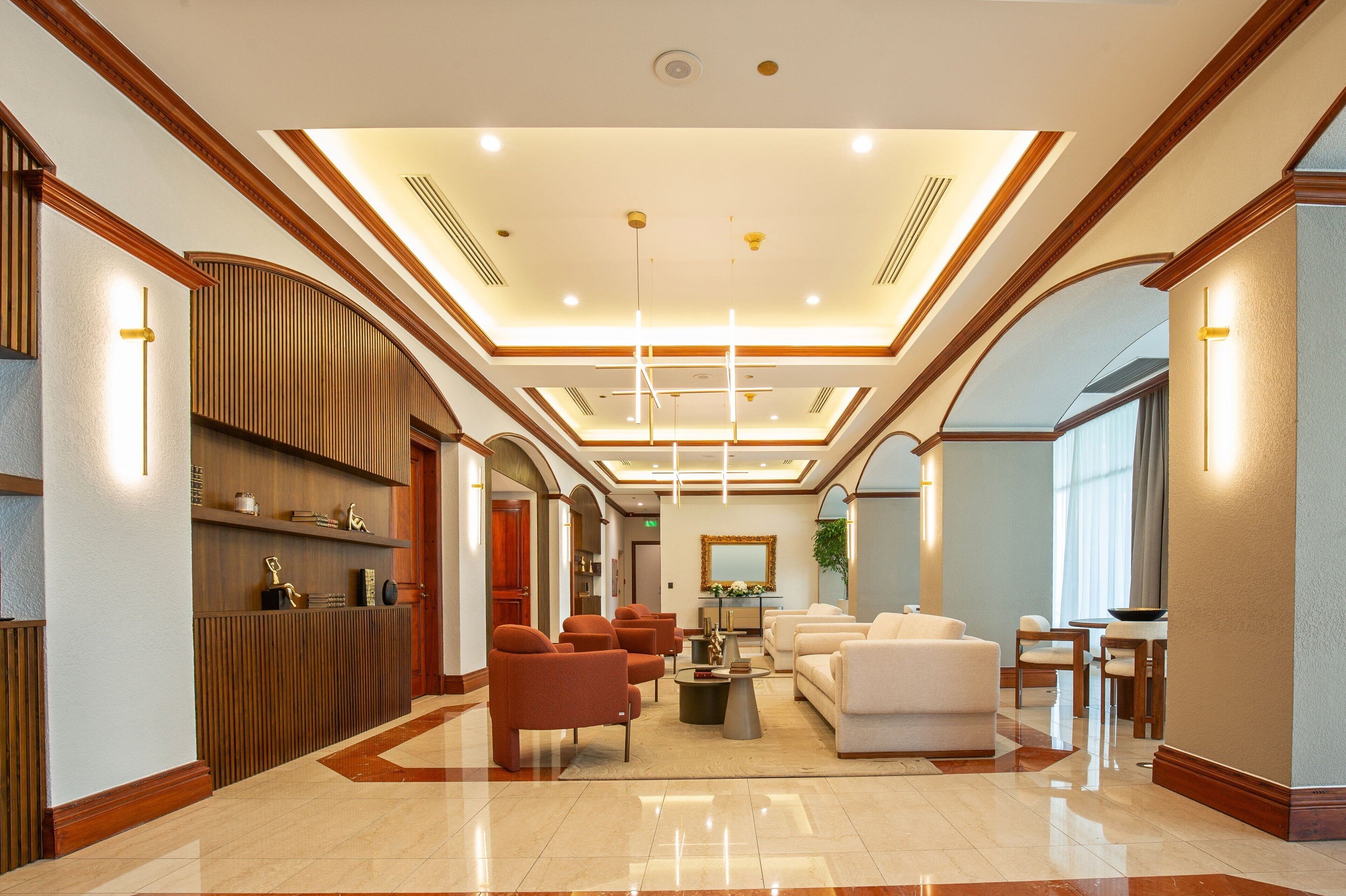 A spacious lobby with a high ceiling, a reception desk, and seating areas.