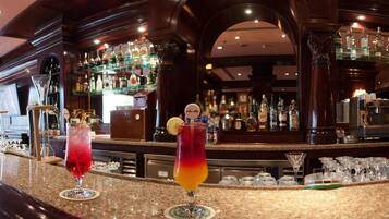 A bar area with a variety of liquor bottles and a coffee machine.