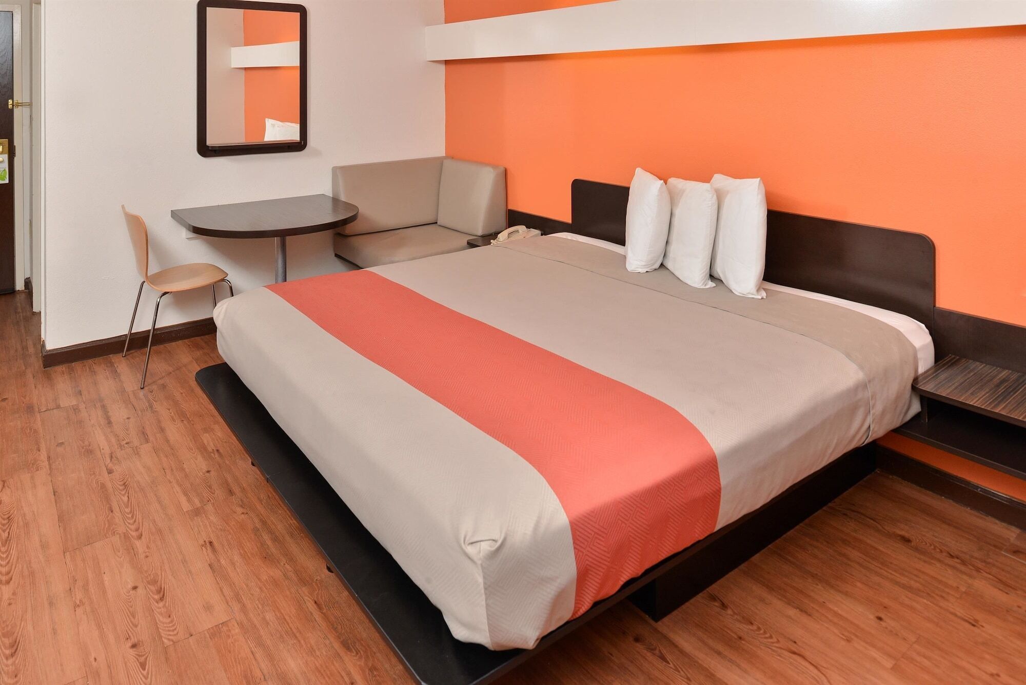 A hotel room with a bed, a desk, and a chair.