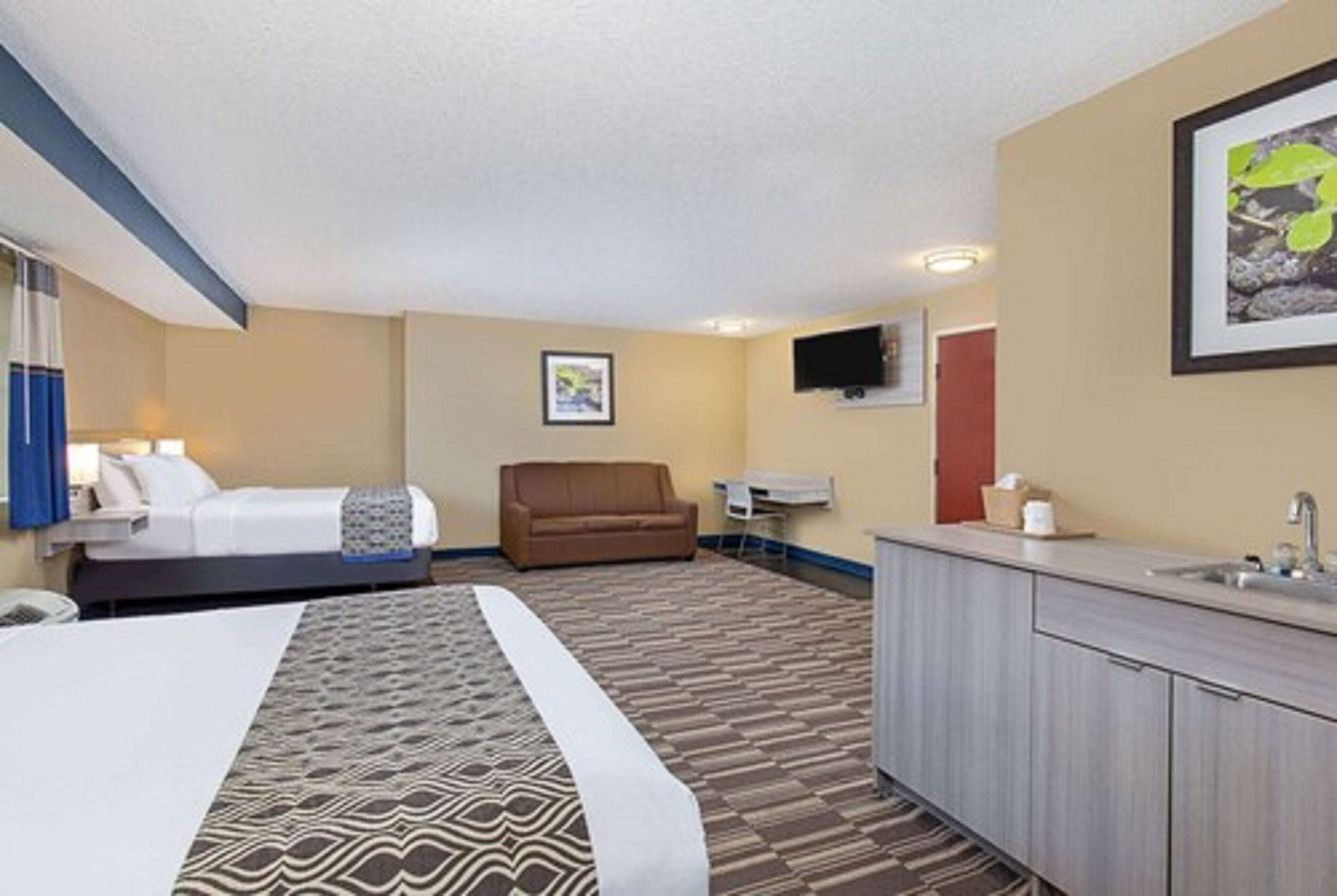 Una habitación de hotel con cama, sofá, escritorio y baño.