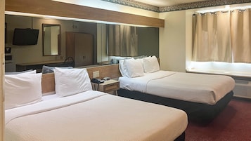 Cubrecamas, escritorio y espacio para trabajar con laptop