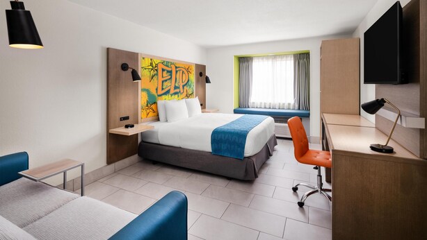 Una habitación de hotel moderna con cama, escritorio y zona de estar.