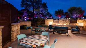 Un patio al aire libre con muros de piedra, una chimenea y zonas de estar.
