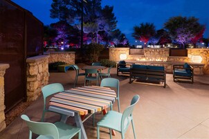 Un patio al aire libre con muros de piedra, una chimenea y zonas de estar.