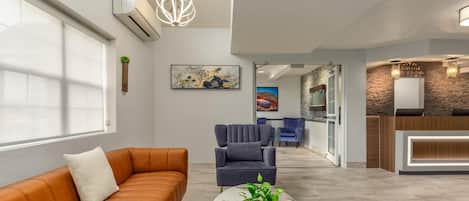 A modern reception area with a reception desk, seating area, and artwork on the walls.