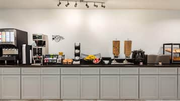 Un área de cocina con una cafetera, un reloj y diversos electrodomésticos.