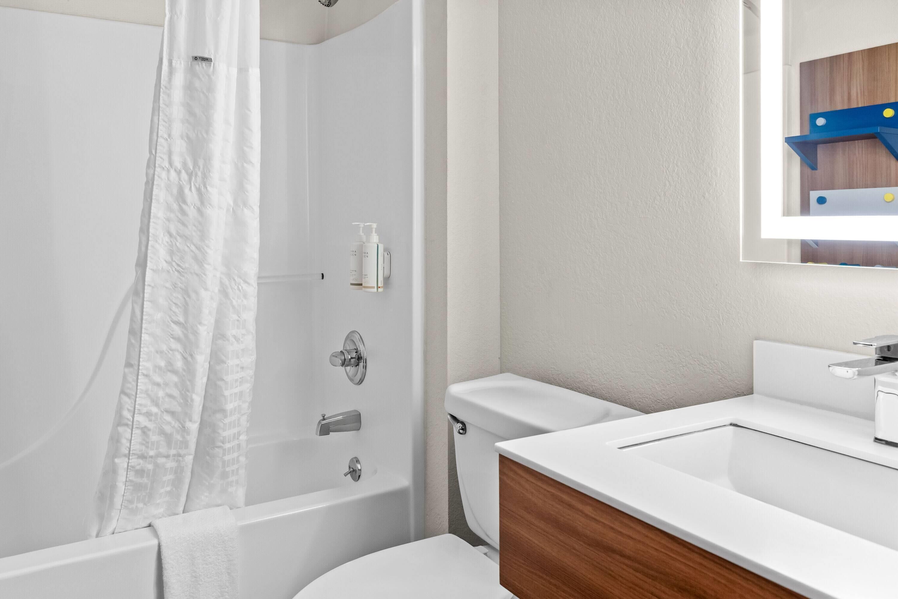 A modern bathroom with a bathtub, toilet, and sink.