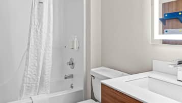 A modern bathroom with a bathtub, toilet, and sink.