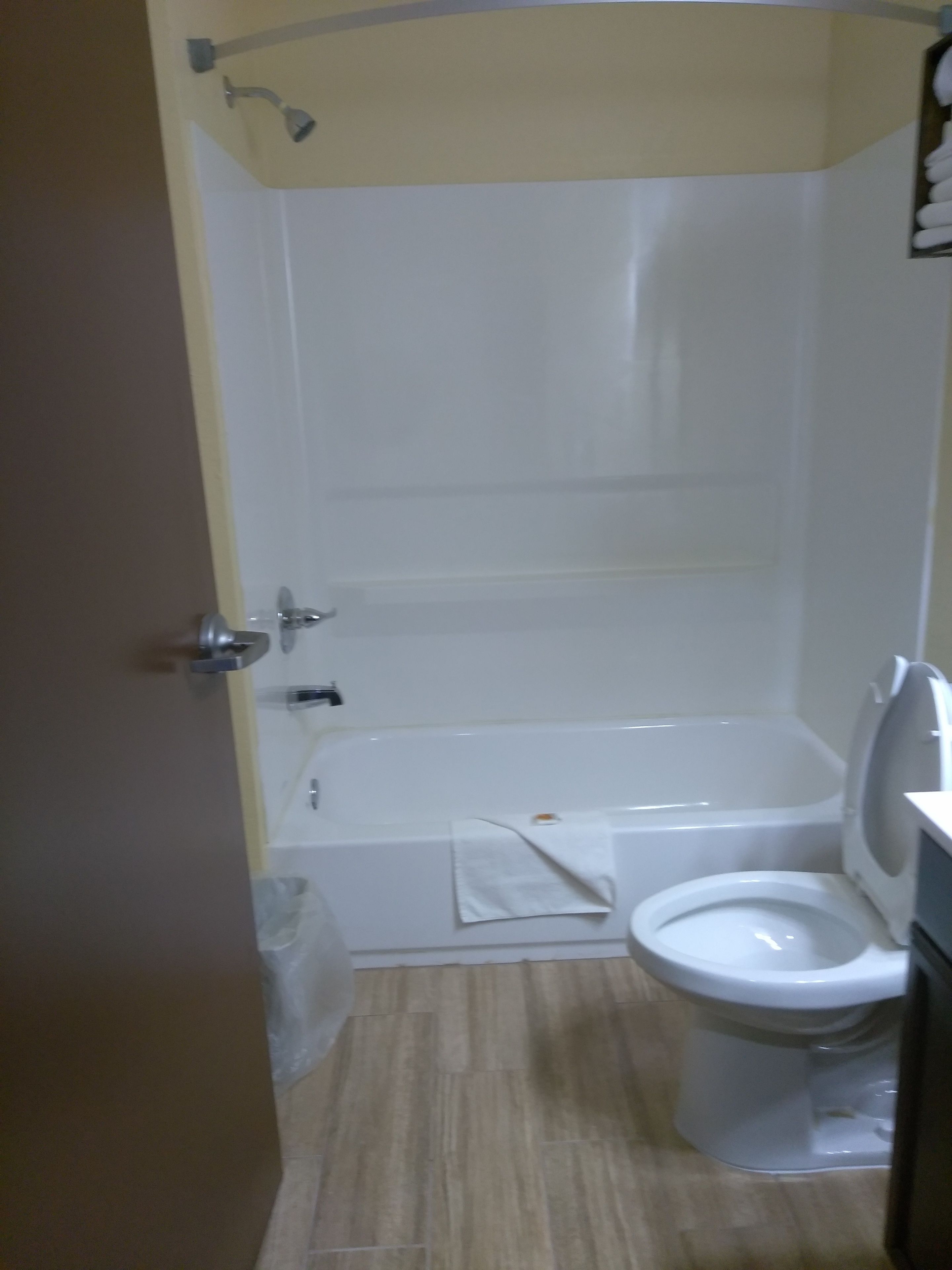 A bathroom with a bathtub, toilet, and shower.