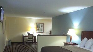 A hotel room with a bed, a desk, and a chair. - Expo Inn Hotel (Tulsa)