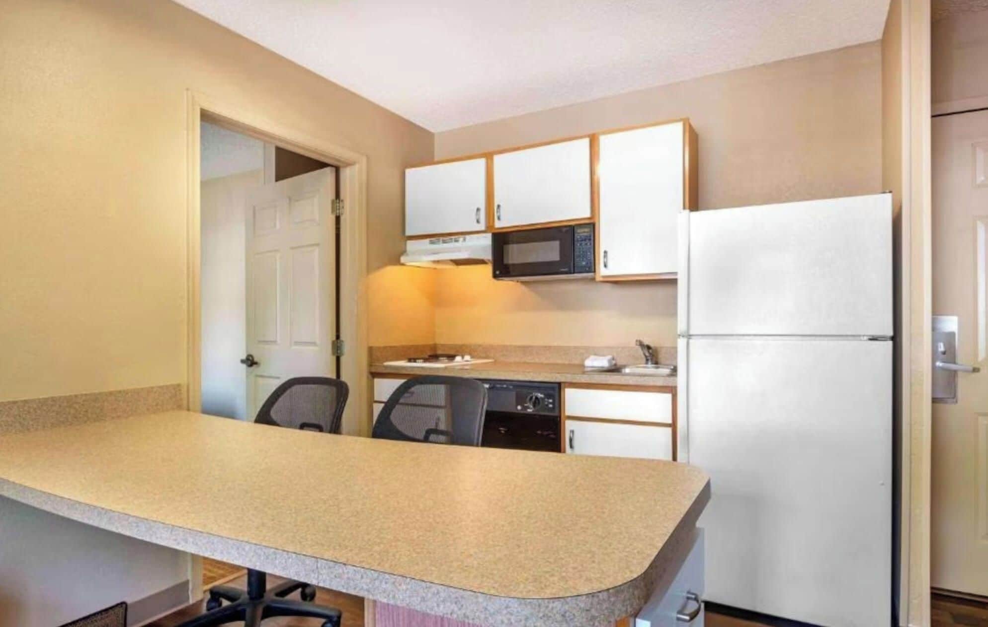 A compact kitchen with a microwave, refrigerator, and a dishwasher.