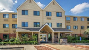 A multi-story hotel with a central entrance, a lobby area, and a parking sign indicating handicapped accessibility. - Extended Stay America Suites - Charleston - Airport (North Charleston)